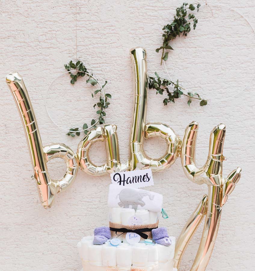 Der stylische "baby" Script Ballon in metallic Gold ist der Eye Catcher über dem Geschenketisch zur Babyparty © juliafashionblonde