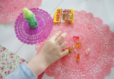 Sei kreativ und nimm bunte Doilies als schnelle und leichte Tischdeko für die Babyparty mit Kindern