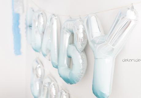 Einzigartige Wand-Deko für eure Jungen-Babyparty: Glänzende Folienballons wurden mit blauer Kreidefarbe angesprüht. Foto: delari.de