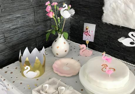 Der Schwan-Geburtstagskuchen hinter dem Schwanensee - mit rosafarbenen Schwänen, die nur ganz zufällig Flamingos ähneln :) Goldene Tupfer und Kronenkonfetti runden das Bild ab © eminecreative