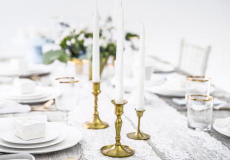 Dinnerkerzen und schöne Kerzenhalter bringen Eleganz in die Tischdeko zur Taufe